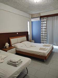 um quarto com 2 camas e uma janela em Oceanida Bay Hotel em Pythagoreio