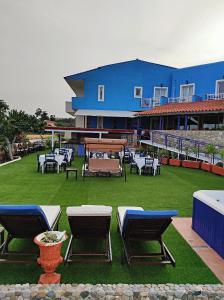 een gebouw met stoelen en tafels op een gazon bij Oceanida Bay Hotel in Pythagoreio