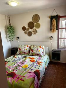 ein Schlafzimmer mit einem Bett mit einer bunten Bettdecke in der Unterkunft La Casa Chica in La Cala de Mijas