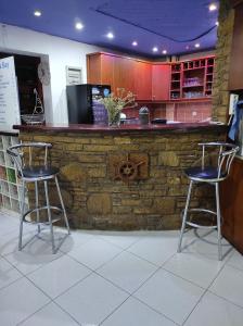 two bar stools in front of a stone counter at Oceanida Bay Hotel in Pythagoreio