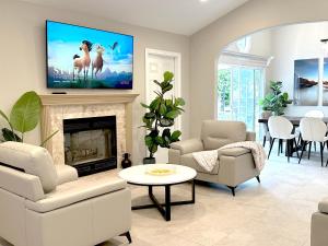 a living room with a tv above a fireplace at Disneyland Vineyard Villa 6Bed 4Bath Game in Anaheim