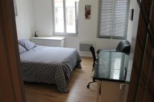 ブザンソンにあるAPPARTEMENT CENTRE HISTORIQUEのベッドと机と椅子のある寝室