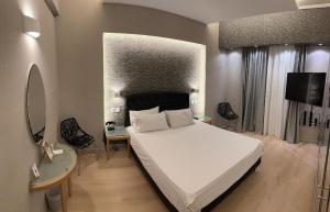 sypialnia z dużym białym łóżkiem i telewizorem w obiekcie Kreoli Hotel w Atenach