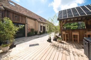 une terrasse en bois avec une maison et un garage dans l'établissement LE RELAIS DES CALECHES - La Jungle Room, 