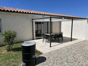 un patio con un tavolo e un ombrellone di Vacances en Ardèche "maison pont d'arc" a Vallon-Pont-dʼArc