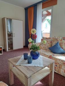 a living room with a table with flowers on it at Haus Lieberum, Ferienwohnung 2.Etage mit Balkon in Bad Sooden-Allendorf