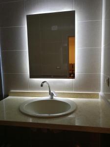 een wastafel in de badkamer met een grote spiegel erboven bij Louran Residence Hotel Apartments in Alexandrië