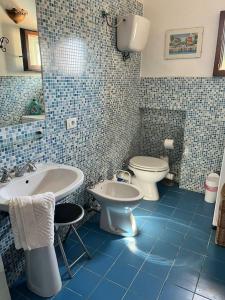 un bagno piastrellato blu con lavandino e WC di Il Ponticello Cortona a Cortona