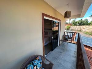 uma varanda de uma casa com uma porta e uma cadeira em Pousada Ventos da Barra em Barra de Santo Antônio