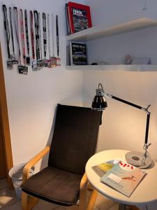 a desk with a chair and a table with a lamp at Ferienwohnung am Nürburgring in Siebenbach