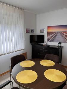 a dining room with a table and four chairs at Ferienwohnung am Nürburgring in Siebenbach