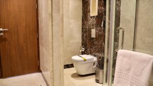 uma casa de banho com um WC e uma cabina de duche em vidro. em Five Seasons Hotel em Tabuk