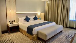 um quarto de hotel com uma cama grande e uma janela em Five Seasons Hotel em Tabuk
