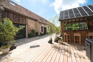 a wooden deck with a house with a garage at LE RELAIS DES CALECHES - l'Appartement "L'aparté" in Broué