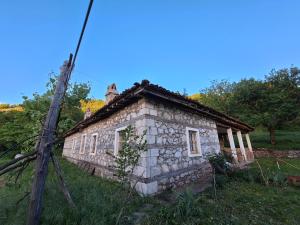 una vecchia casa in pietra, seduta in cima a un campo. di Revita Stone House a Elbasan
