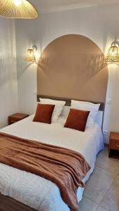 um quarto com uma grande cama branca e 2 almofadas em T2 de 45 m2 sur Porticcio avec Jardin em Porticcio