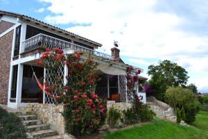 a house with a bunch of flowers in front of it at Miravalle Suites in Paipa