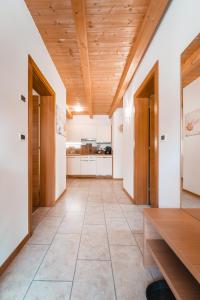 a kitchen with a wooden ceiling and a wooden table at ALMRESIDENZ UNTERRAIN -1 km BY CAR DISTANCE SKI SLOPES KRONPLATZ in Valdaora