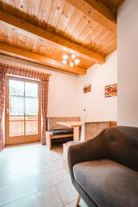 uma sala de estar com um sofá e uma mesa em Almresidenz Unterrain zum Hartl -1 km BY CAR DISTANCE SKI SLOPES KRONPLATZ em Valdaora
