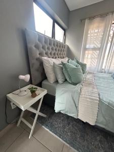 een slaapkamer met een bed en een tafel met een nachtkastje bij Langebaan Holiday Home in Langebaan +31 foto's