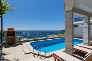 a view of the pool and ocean from a house at Luxury condo with fantastic view and private pool in Komoševina