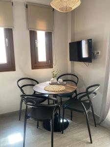 耶里索斯的住宿－Αura Luxury Apartments，一间带桌椅和电视的用餐室