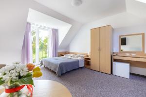 een hotelkamer met een bed en een tafel met bloemen bij DG Albatros II in Rewal