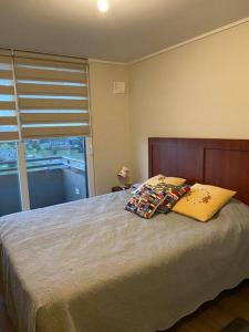a bedroom with a bed with two pillows and a window at Cómodo y agradable departamento, 2 habitaciones in Llanquihue