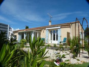 una pequeña casa con una silla azul delante en Eclats du Sud en Auriol