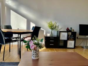 sala de estar con mesa y jarrón con flores en Skøn stort arkitekt tegnet lejlighed, en Charlottenlund