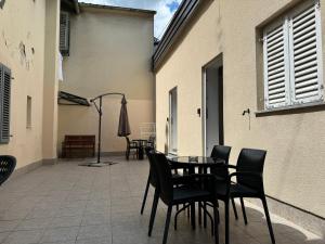 a patio with chairs and a table and an umbrella at Apartments Ascic in Opatija