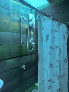 a shower curtain with a blow dryer hanging on a wall at Silaa Cabana in Trincomalee