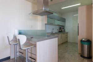 a kitchen with a counter and some chairs in it at Luxury condo with fantastic view and private pool in Komoševina