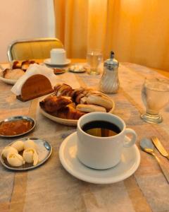 een tafel met een kopje koffie en een bord gebak bij Hotel Cervantes in Termas de Río Hondo