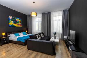 1 dormitorio con cama, sofá y TV en Skackavá apartmán v centre Banskej Bystrice, 24h self check-in en Banská Bystrica