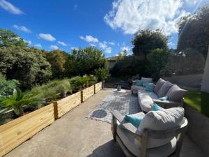 a patio with couches and chairs in a garden at Le Val d'escure in Saint-Raphaël