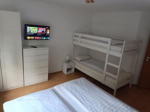 a bedroom with a bunk bed and a television at Ferienwohnung Latscha - 2 Zimmer Wohnung mit Klimaanlage,Balkon, Kinderspielplatz in Ettenheim