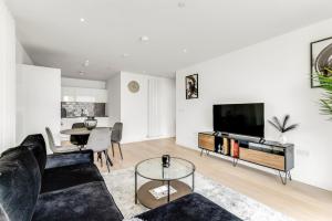 a living room with a couch and a tv at Khayat Homes - The Khalifa - One Bed Luxury APt in London