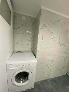 a washer and dryer in a bathroom with a wall at Chrisa's Home in Paloúkia