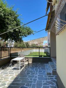 een tafel en stoel op een patio met een balkon bij Chrisa's Home in Paloúkia