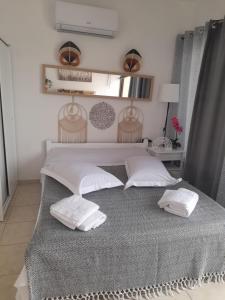a bedroom with a bed with two pillows on it at Heraklion Centre Experiene in Heraklio
