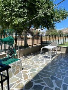 a patio with a table and chairs and a fence at Chrisa's Home in Salamina