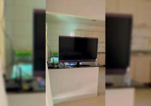 una TV a schermo piatto seduta sopra un bancone di Casa aconchego em Blumenau a Blumenau