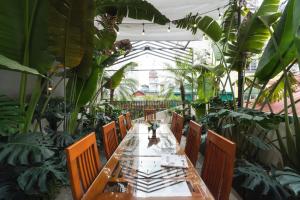 una mesa y sillas en un invernadero con plantas en Le's home boutique homestay in the center Hanoi Old quarter, en Hanói