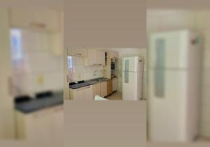 una cucina con armadietti bianchi e frigorifero di Casa aconchego em Blumenau a Blumenau