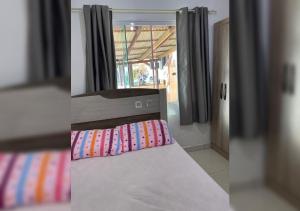 een slaapkamer met een bed en een raam bij Casa aconchego em Blumenau in Blumenau