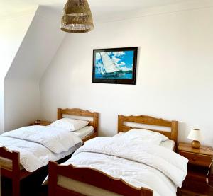 two beds in a room with a picture on the wall at Appartement Solidor Vue Mer in Saint Malo