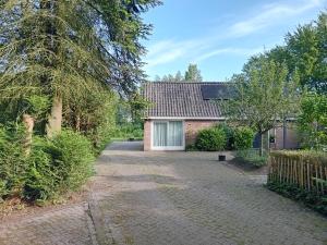 uma entrada que leva a uma casa com garagem em Ruim huisje op een prachtige plek em Hemrik
