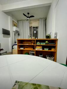 uma sala de estar com uma ventoinha de tecto e uma mesa em Studio no Largo da Carioca - Rio de Janeiro no Rio de Janeiro