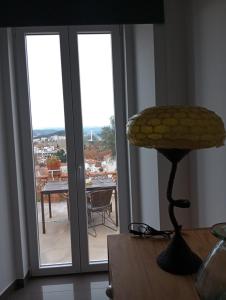 a room with sliding glass doors with a view of a patio at Casa com vista sob a cidade! in Coimbra +13 photos
